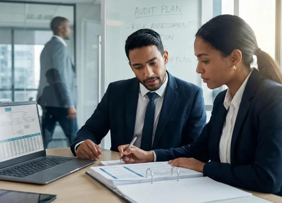 Two advisers working through an audit plan and risk assessment documentation
